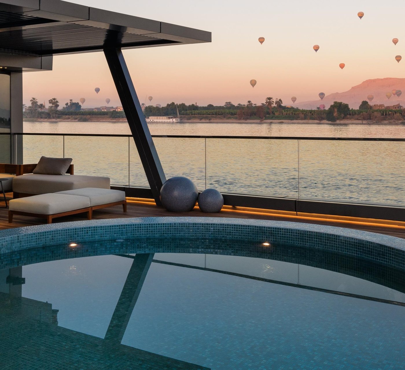 Plunge pool deck at sunrise, with hot-air balloons over the West Bank